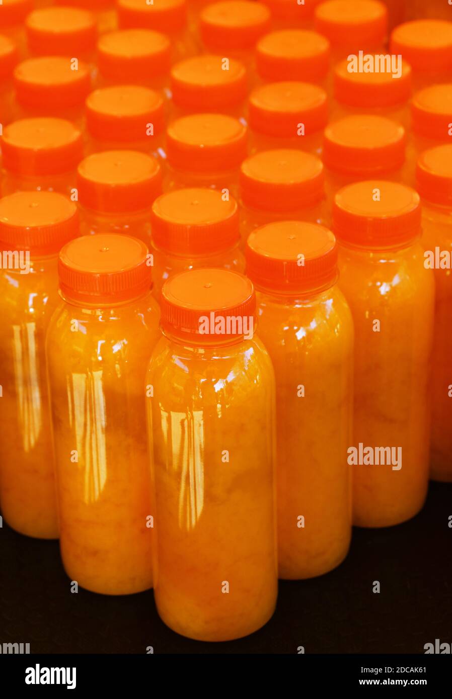 https://c8.alamy.com/comp/2DCAK61/close-up-many-plastic-bottles-of-fresh-orange-juice-at-retail-display-high-angle-view-2DCAK61.jpg