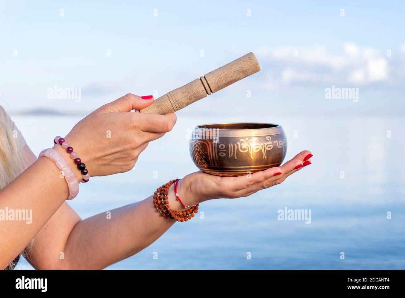 Tibetan singing bowl in female hands on nature background Stock Photo