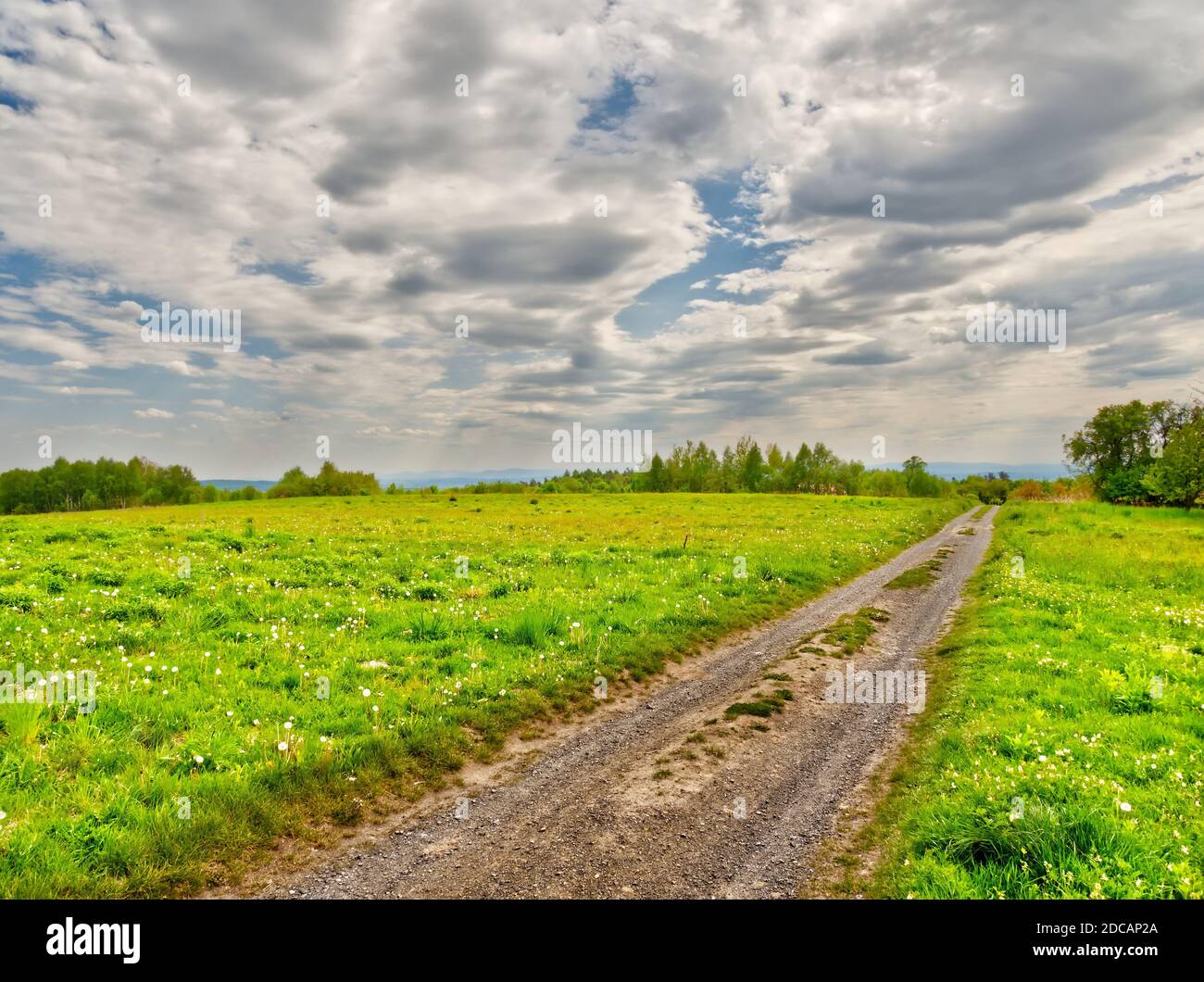 Country road with clouds over it Stock Photo - Alamy