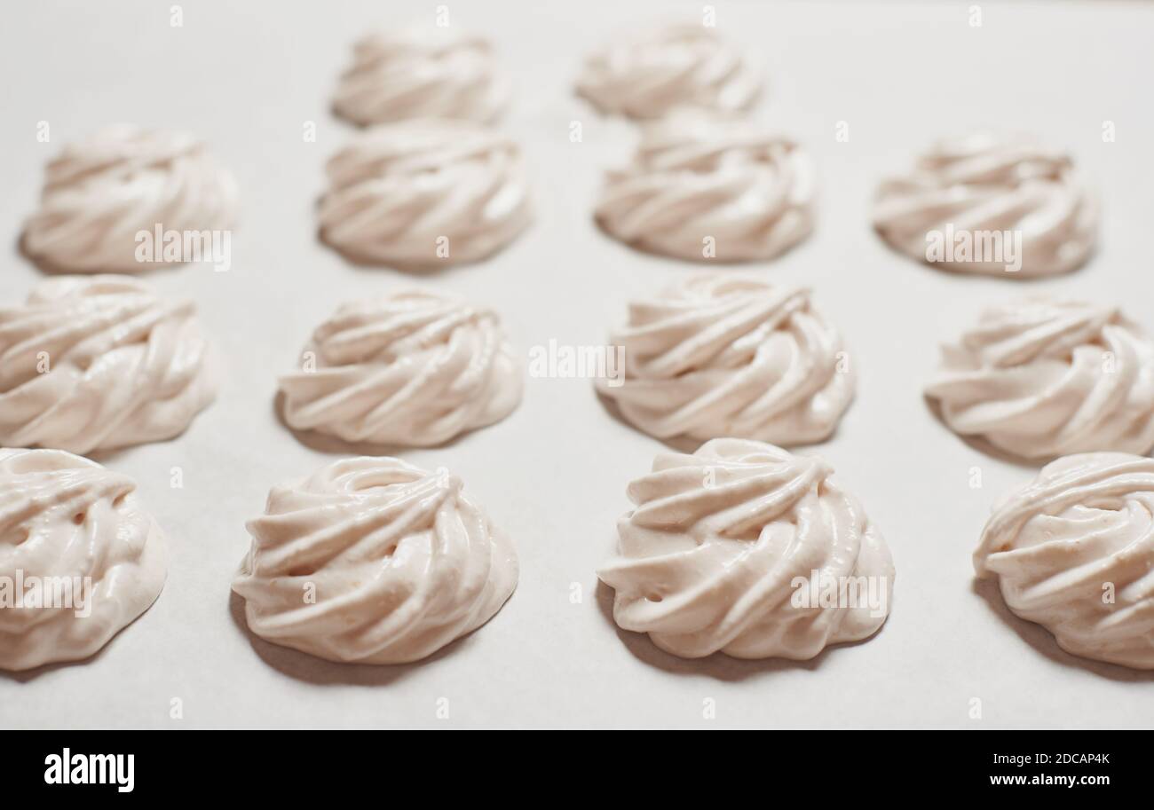 Cooked homemade sweet food a meringue cookies on baking paper Stock Photo