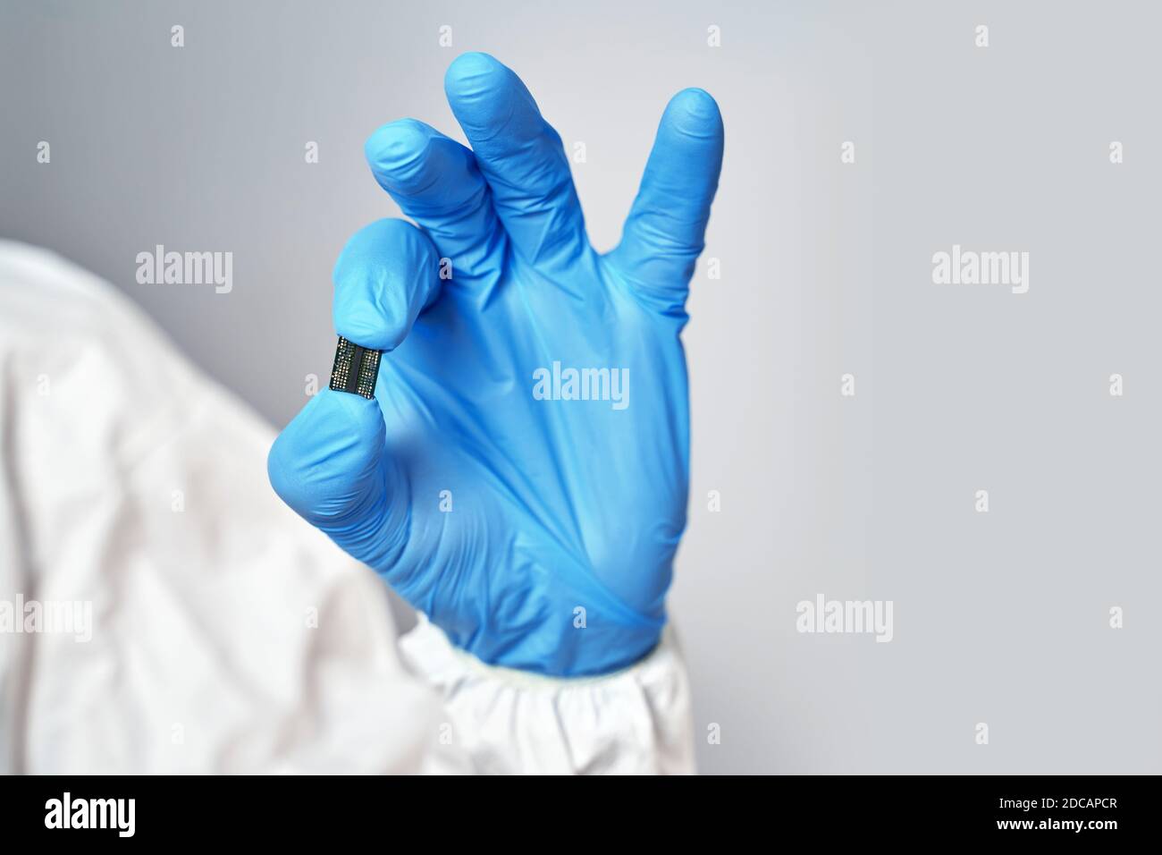 Hand holds chip compenent.. Microchip close-up. Implantation to humanity. Stock Photo