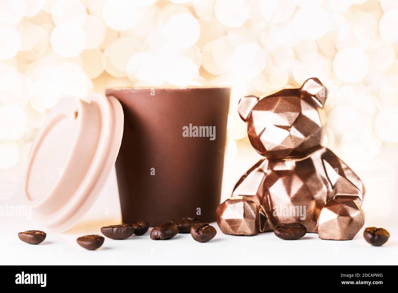 Gift card with chocolate bear and cup of coffee on golden background of  christmas lights bokeh. Mockup for decorative design. Christmas and New  Year c Stock Photo - Alamy