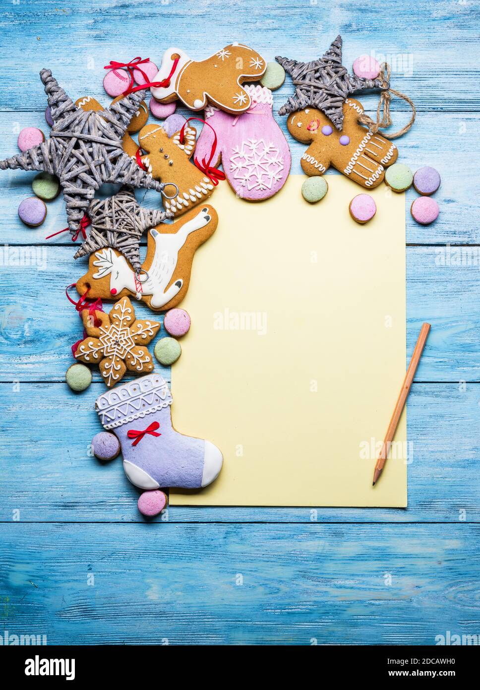 Empty Santa letter with Christmas traditional ginger cookies around it on wooden background. Christmas or New Year holiday background. Top view. Stock Photo