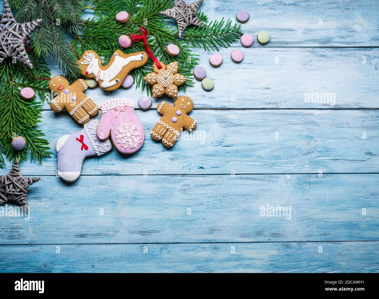 Blue wooden background with christmas decoration and ginger cookies. Christmas or New Year holiday background.  Top view. Stock Photo