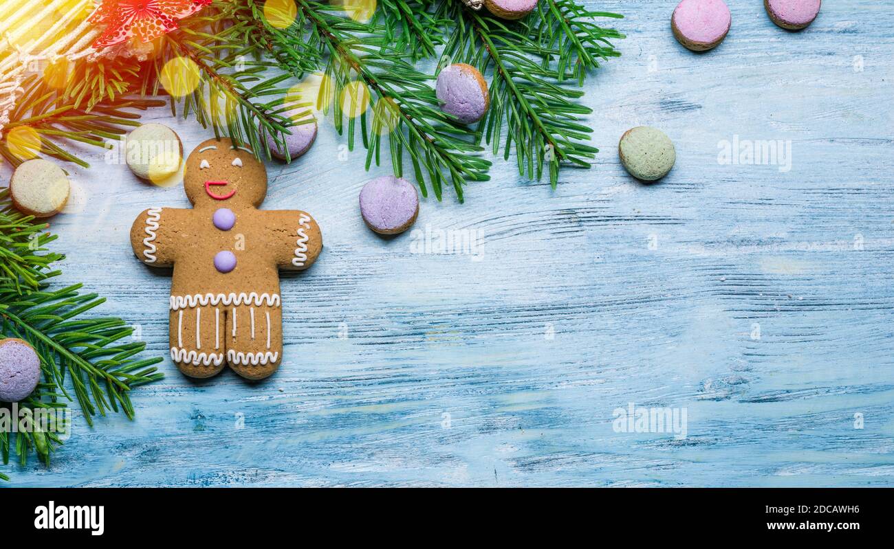 Blue wooden background with christmas decoration and gingerbread man. Christmas or New Year holiday background. Top view. Stock Photo