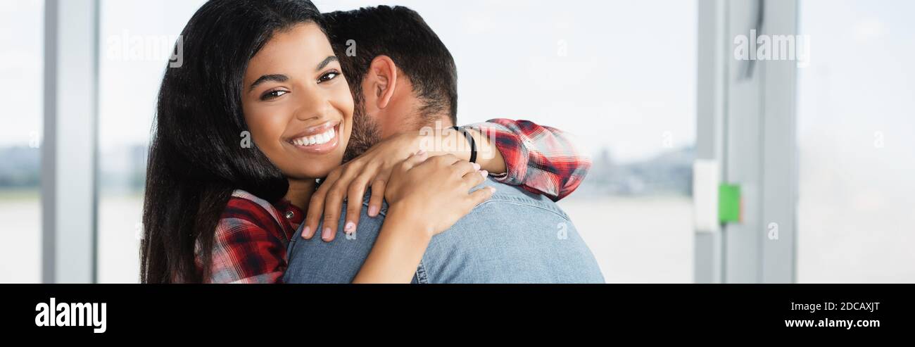 happy african american woman hugging man in airport, banner Stock Photo ...