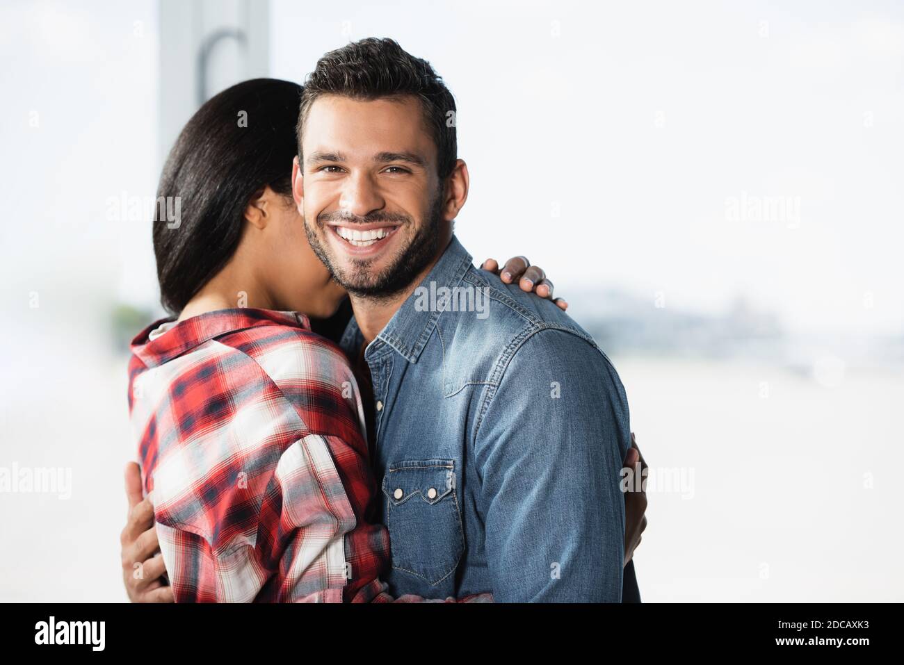 african american woman hugging cheerful boyfriend in airport Stock ...