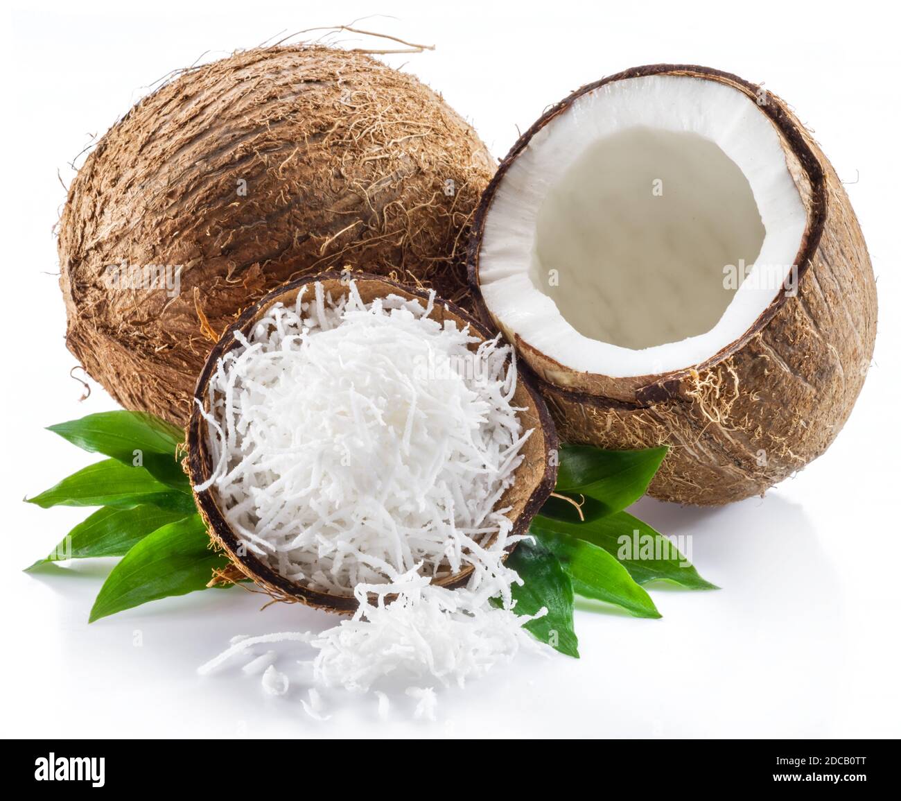 Cracked coconut fruit with white flesh and shredded coconut flakes isolated on white background. Stock Photo