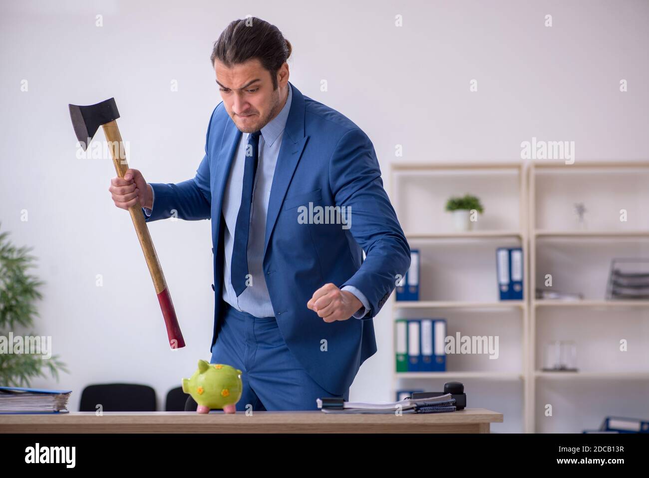 Aggressive employee with hatchet in budget planning concept Stock Photo ...