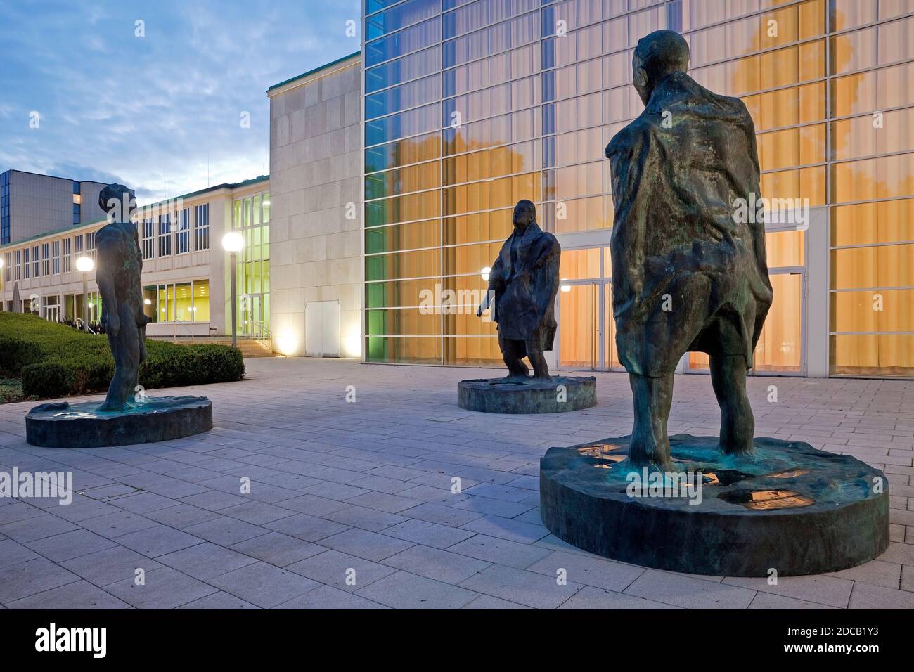 sculpture group 'Man in the Wind I, II, III' in front of the glass foyer of the RWE pavilion of the Saalbau, Germany, North Rhine-Westphalia, Ruhr Stock Photo