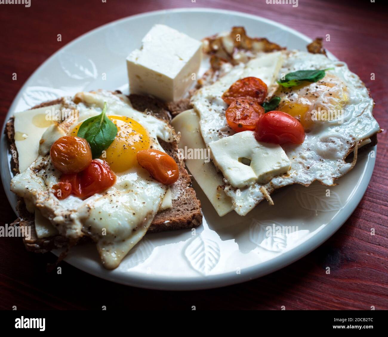 Fried eggs with tomatoes and basil, mediterranean style Stock Photo