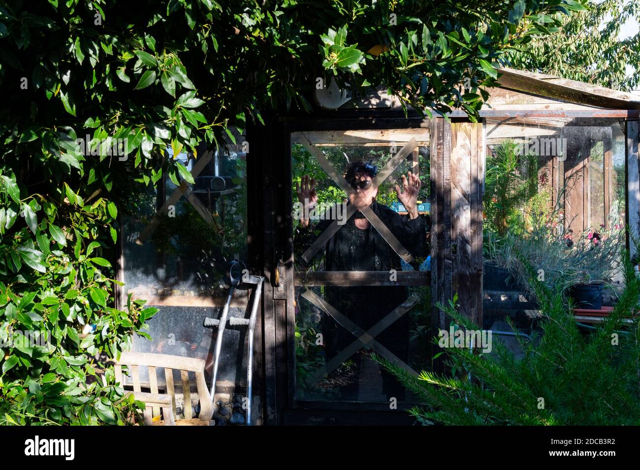 Woman in her garden self isolating during Covid-19 lockdown Stock Photo