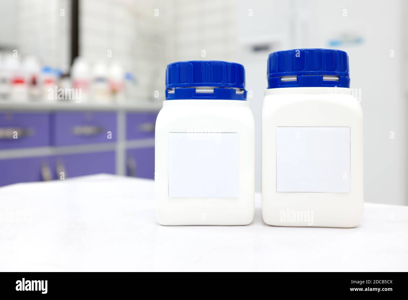 Two unlabeled plastic chemical bottle container with cap in a white