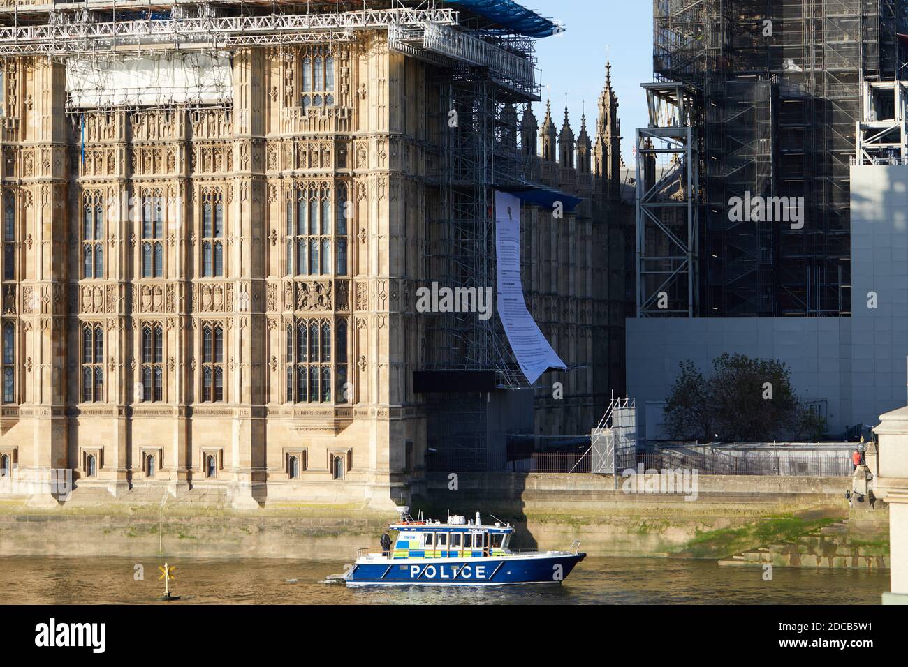 London, UK. - 12 Nov 2020: Police surround demonstrators from the protest group Africans Rising, who have unfurled a large banner on building works at the the side of the Houses of Parliament. Stock Photo