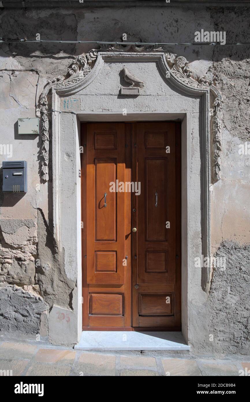 old entrance door in Troina Old Town, as in a well-to-do house of Sicily architecture, framed with decorative elements carved in the stone Stock Photo