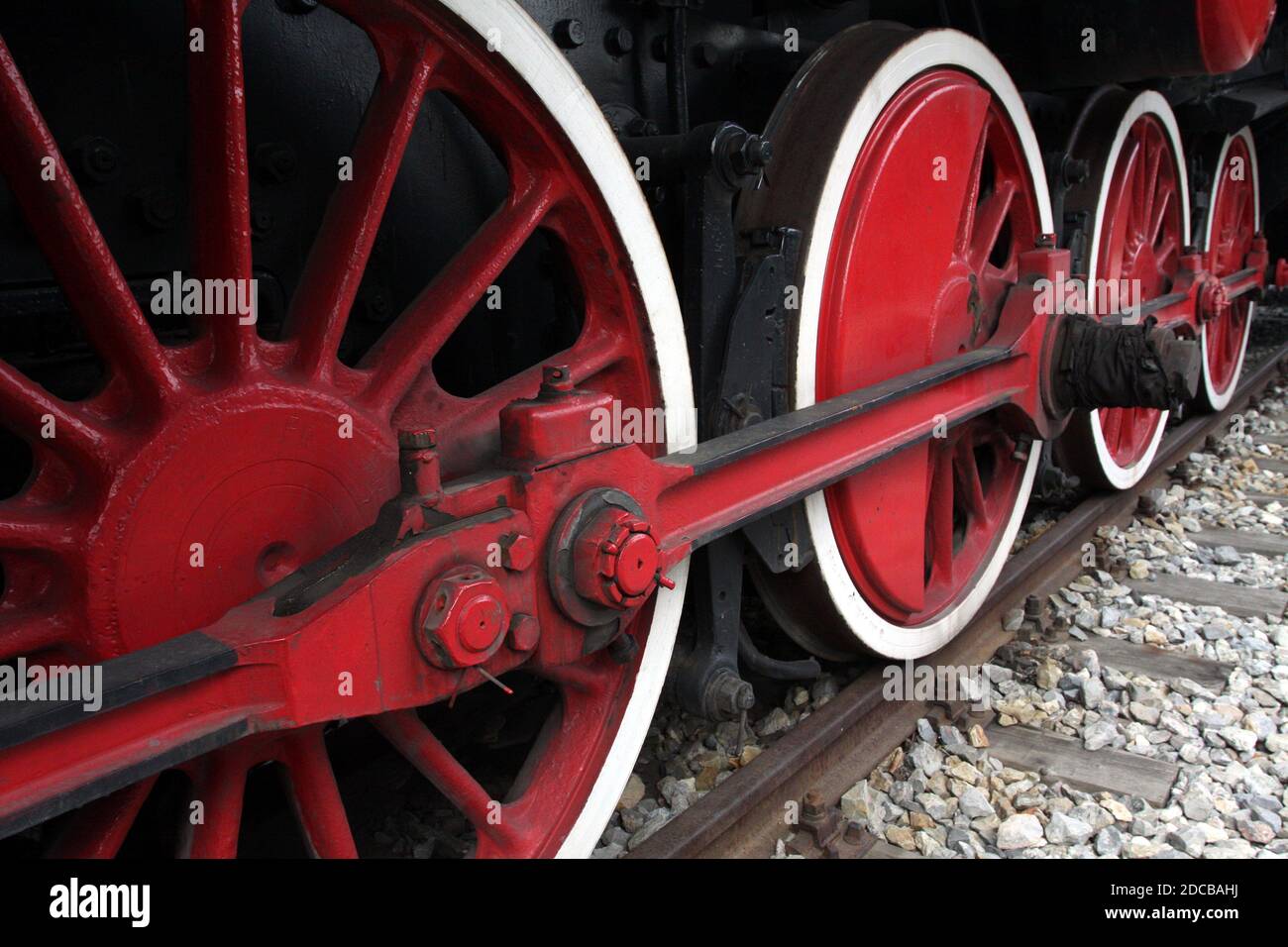 Antique locomotive driving wheels detail. Painted wheels and connecting rods. Stock Photo