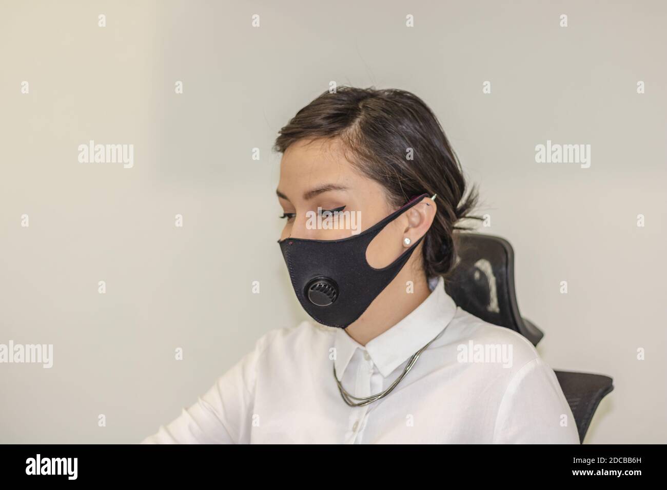 Business woman working in office wearing face mask due to covid19 ...