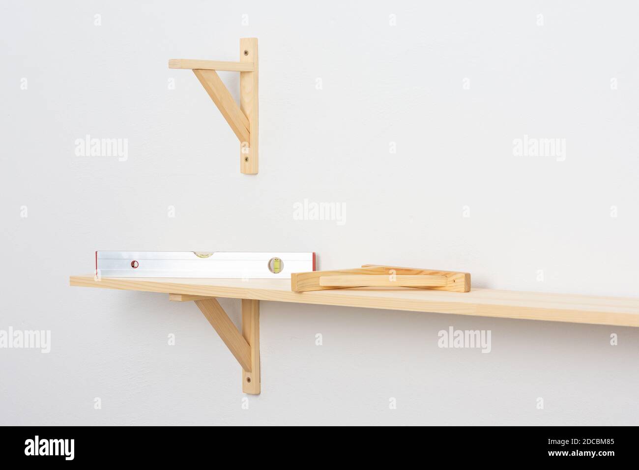 The process of fixing the wooden shelf to the wall, the level tool