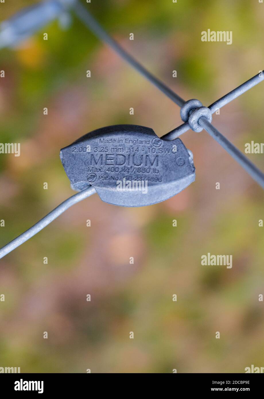 Close-up of a Gripple wire joiner attached to a steel wire fencing. Stock Photo