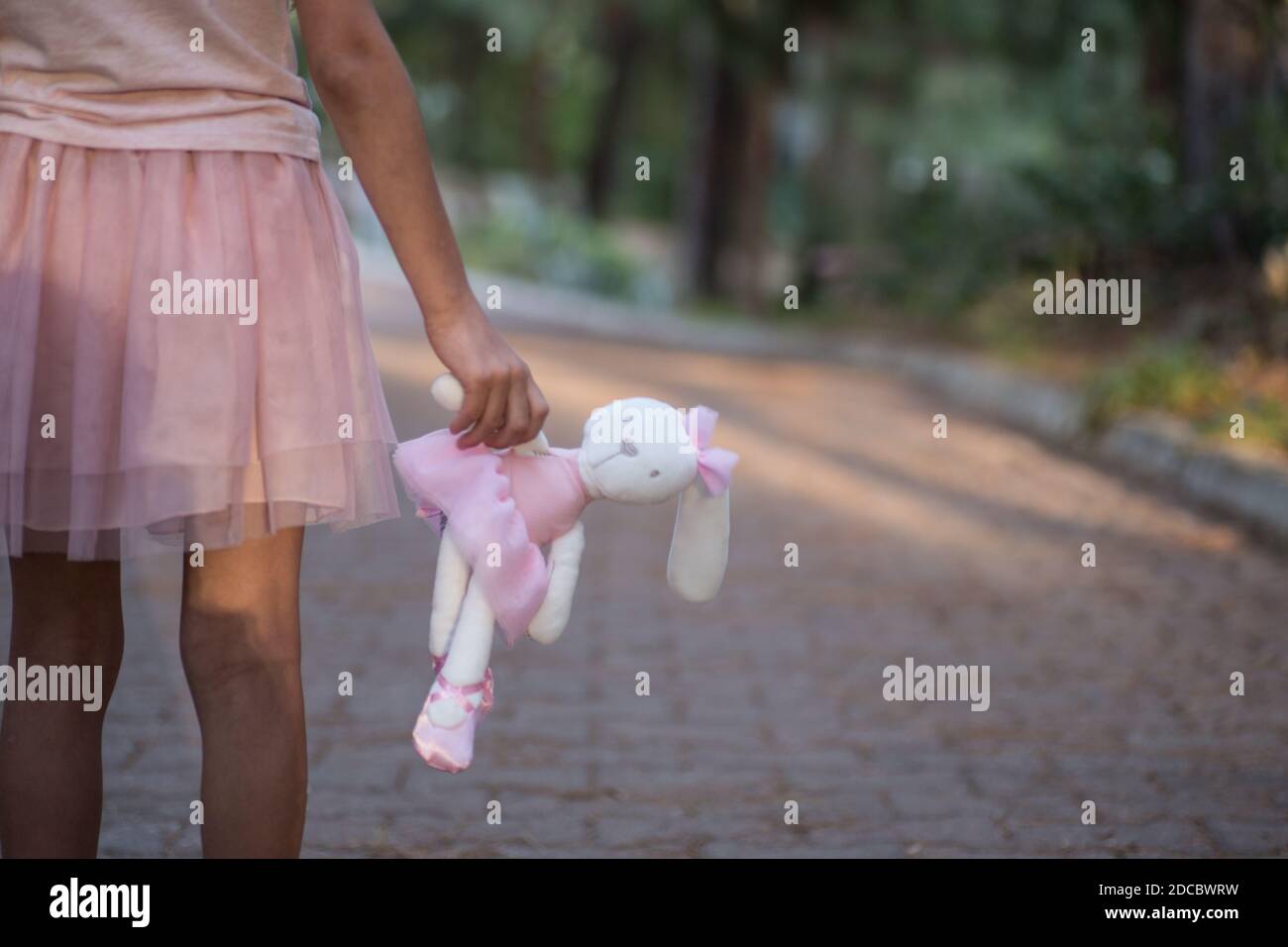 Sad girl hugging teddy bear sadness alone in green garden park. Lonely