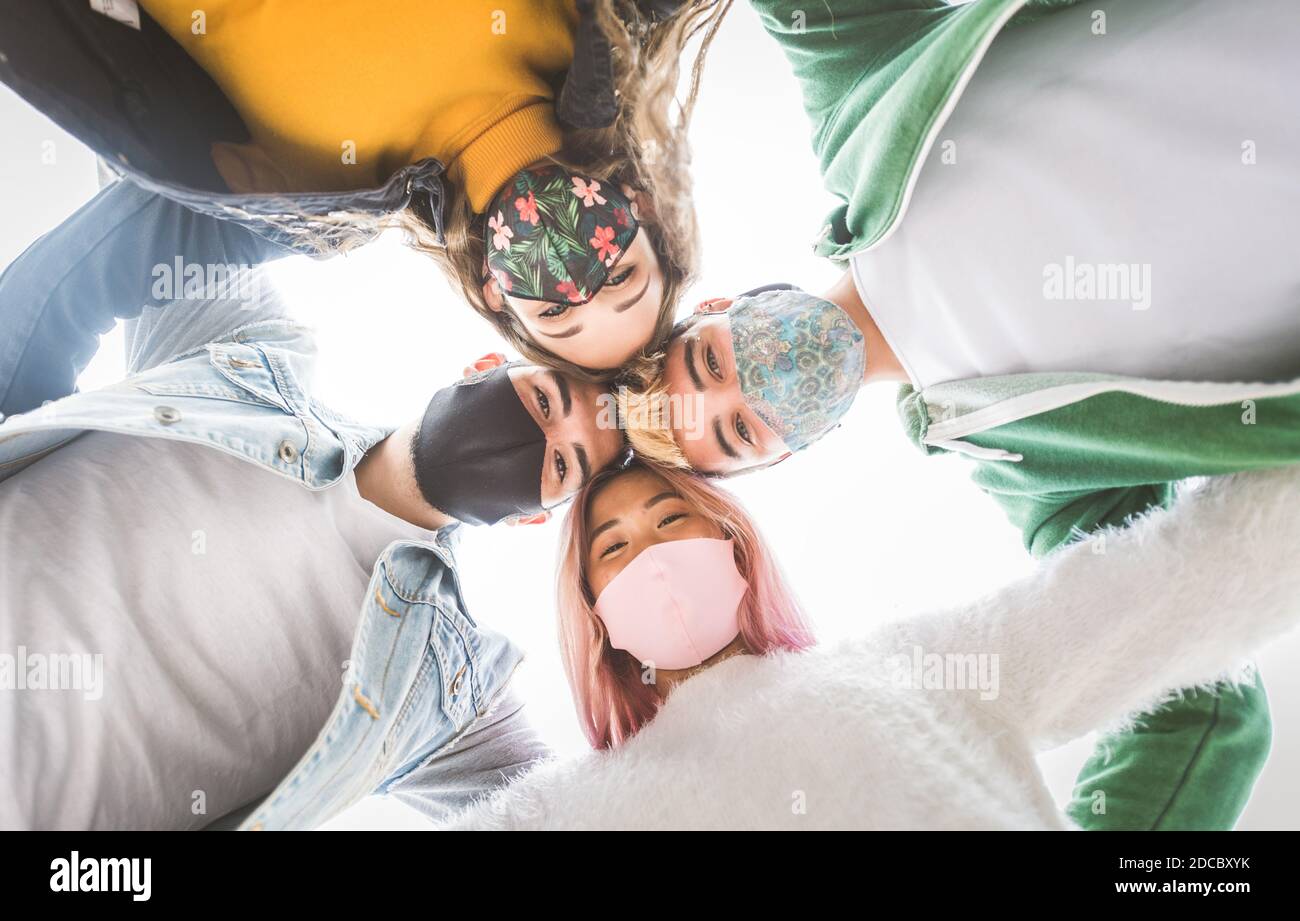 Happy young people meeting outdoors and wearing face masks during covid ...