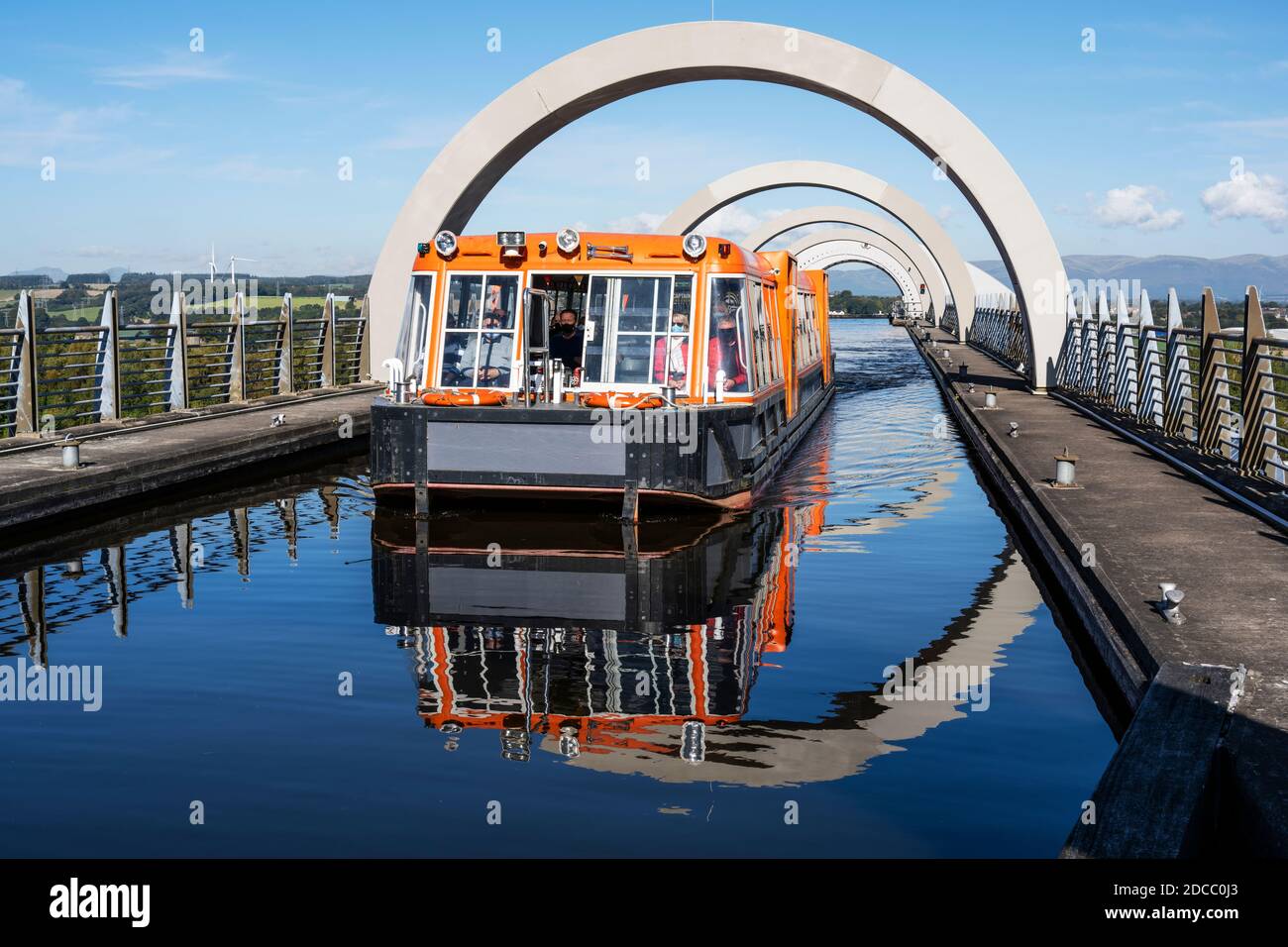 Canal boat on elevated section of canal leaving the top of the Falkirk Wheel rotating boat lift in Falkirk, Scotland, UK Stock Photo