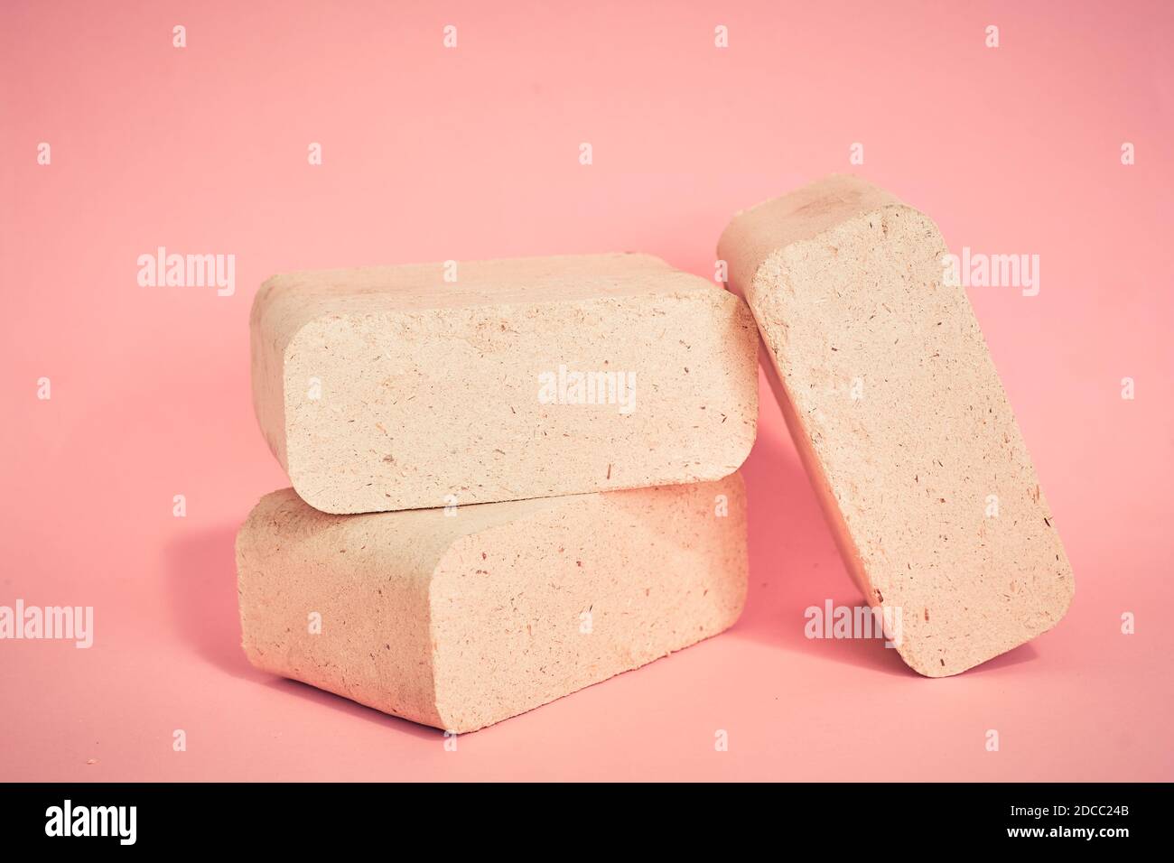 fuel briquettes on a pink background, natural fuel for home heating