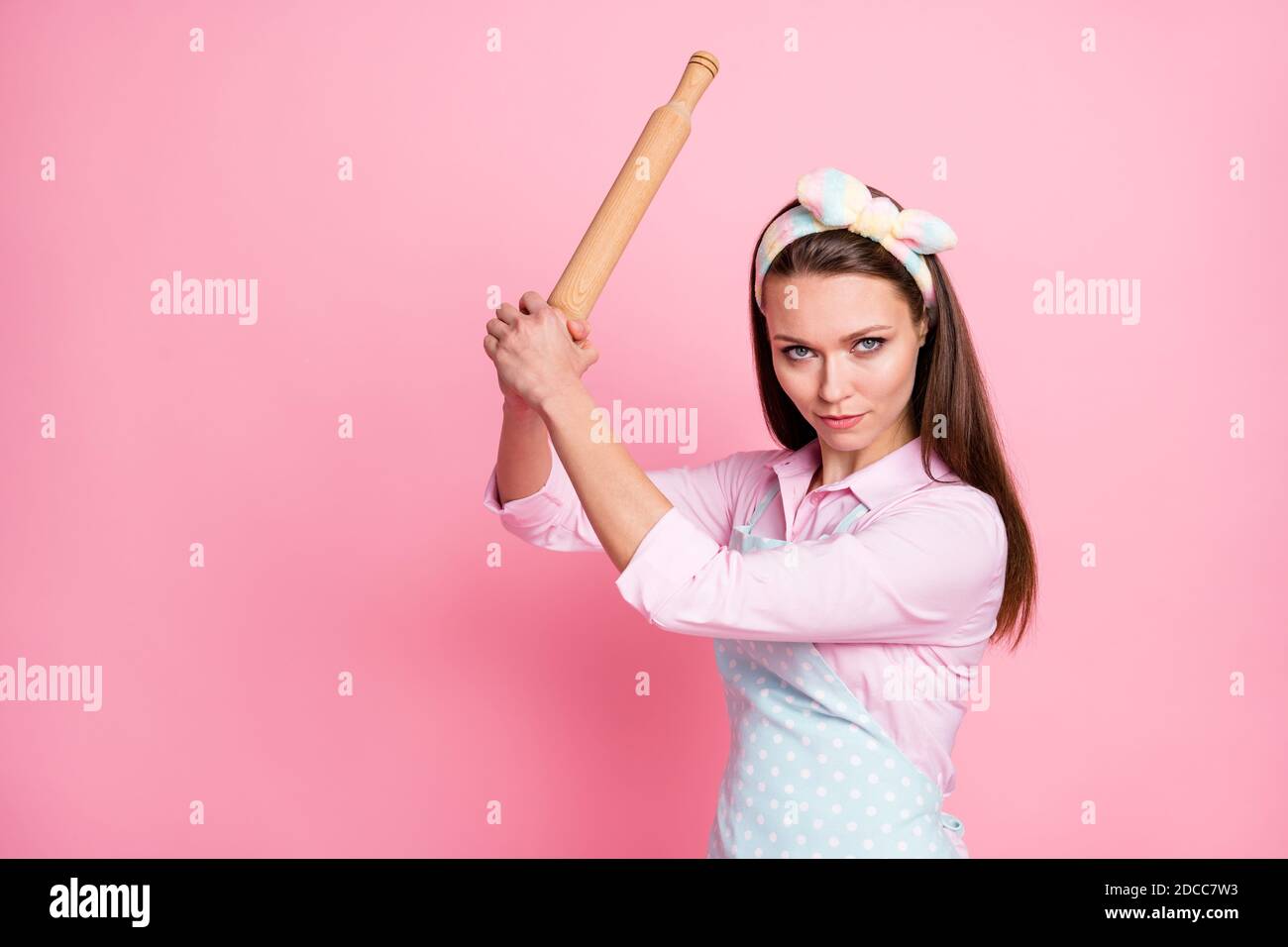 Close-up portrait of her she nice attractive dangerous angry serious housewife holding in hands wooden rolling pin threatening fighting rights Stock Photo