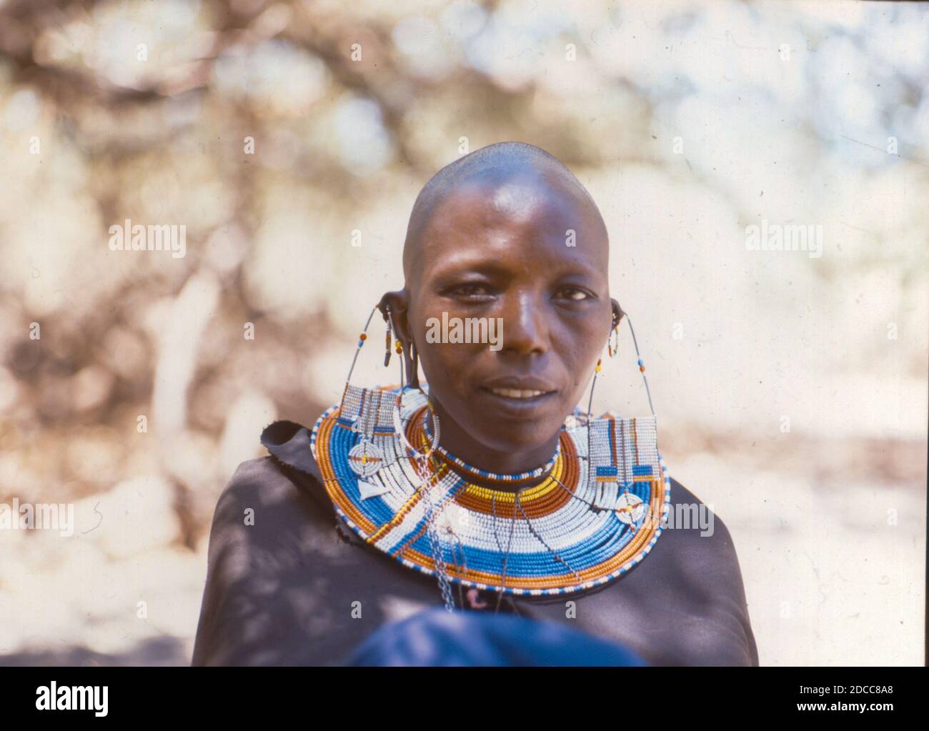 A smiling portrait of a Maasai woman in East Africa taken in the 1960s Stock Photo