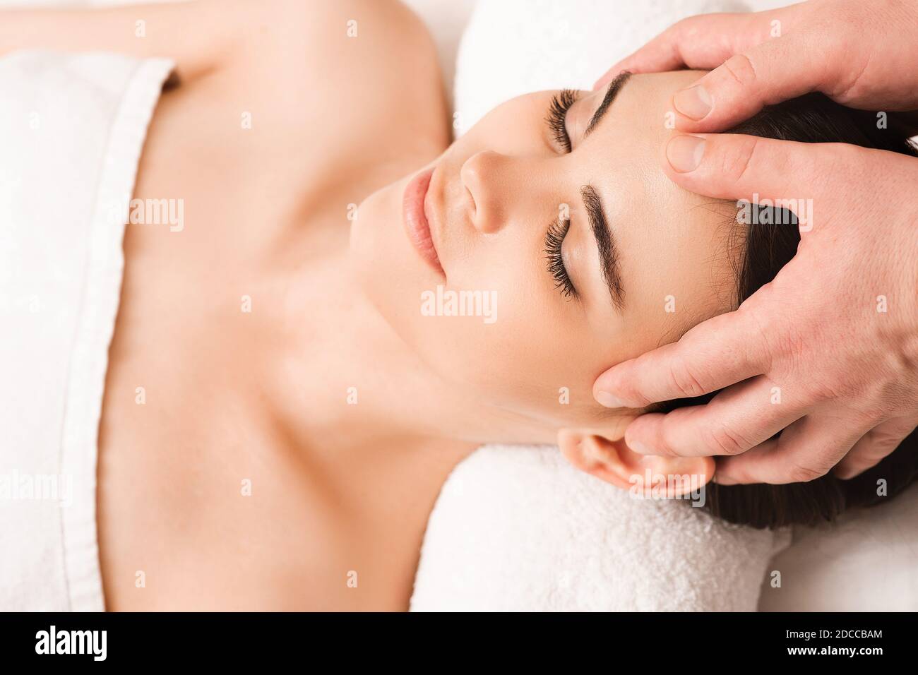 Thai head massage therapy. Mixed race woman enjoys massage at spa. Antistress procedures at wellness salon Stock Photo