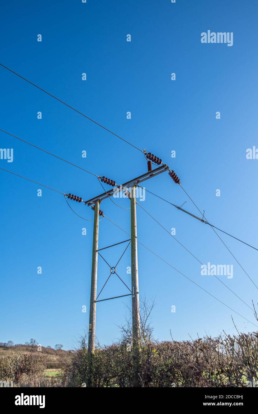 Wooden telegraph pole with wires and insulators with a clear blue sky background Stock Photo