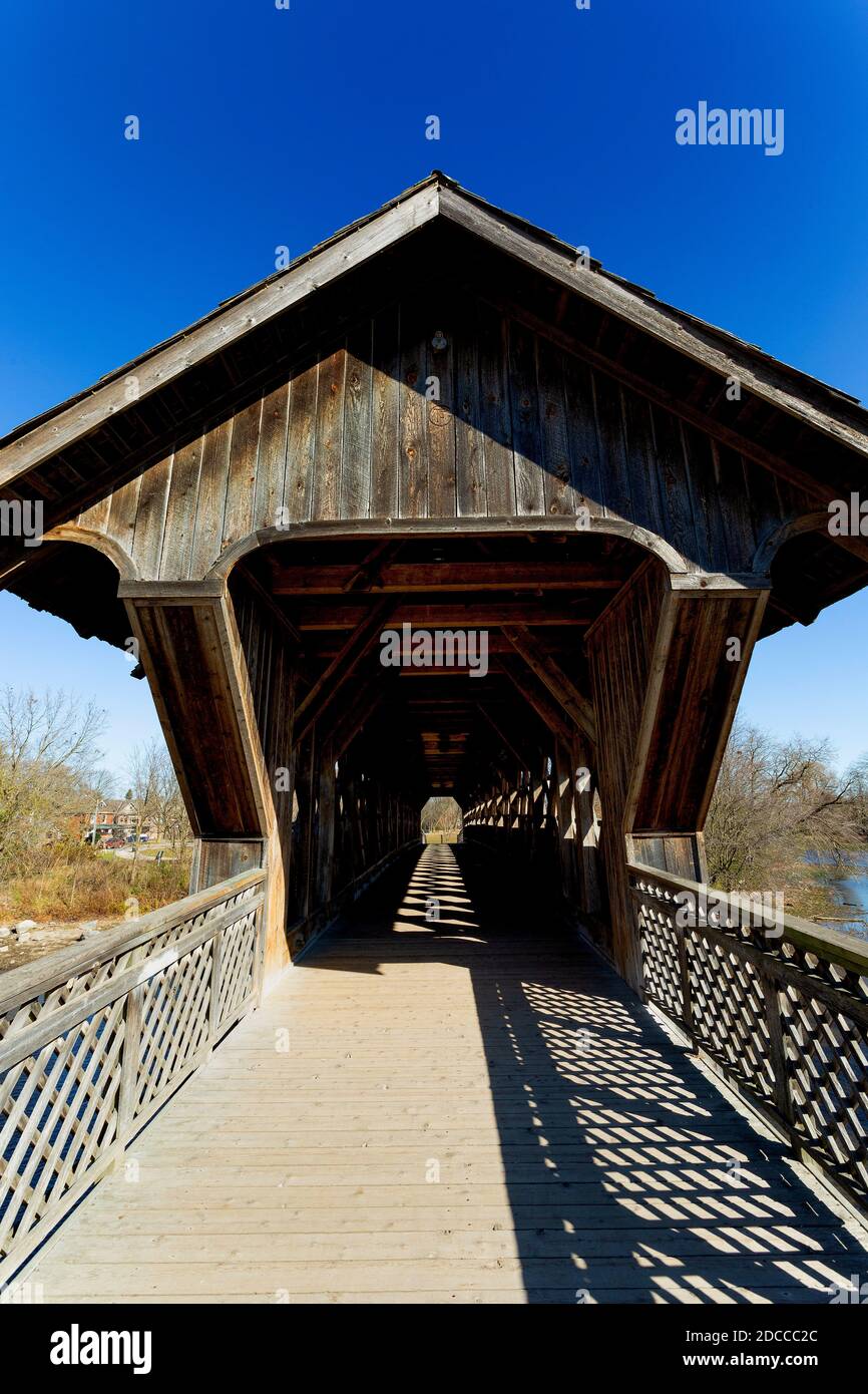 The all wood lattice covered pedestrian & cyclist covered bridge over the Eramosa River built in 1992. Guelph Ontario Canada Stock Photo