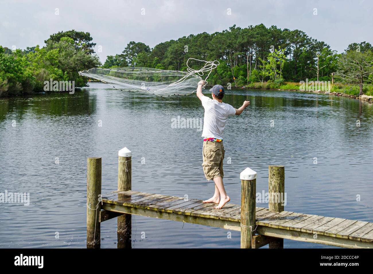 Louisiana St. Tammany Parish Slidell, Liberty Bayou, crabbing fishing man pier tossing net, Stock Photo