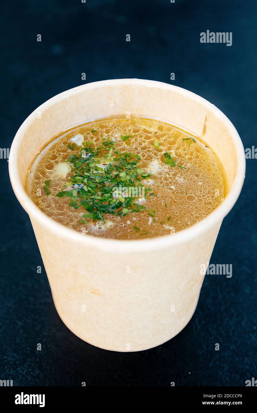 Chicken broth in a paper cup on a dark background Stock Photo Alamy
