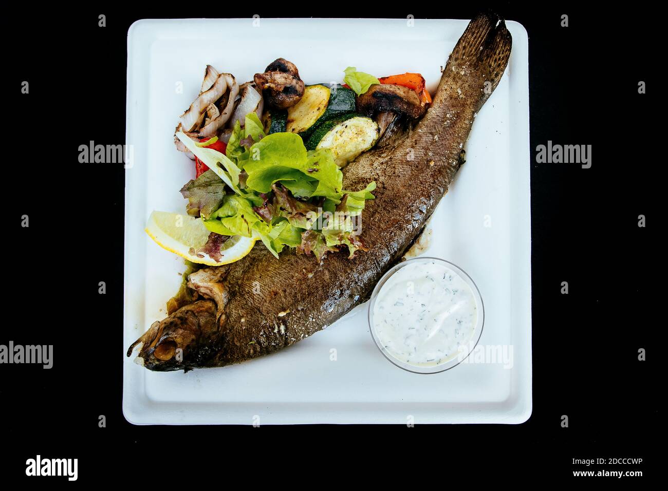 Whole fried trout with herbs and sauce Stock Photo Alamy
