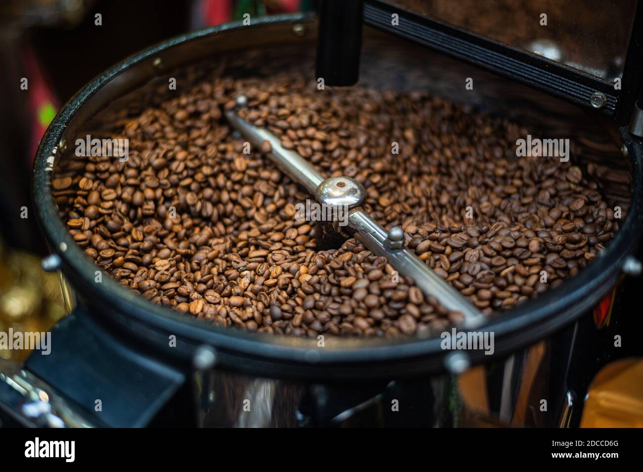 Closeup process of roasting fresh fried coffee beans. Processed coffee beans are mixed around an