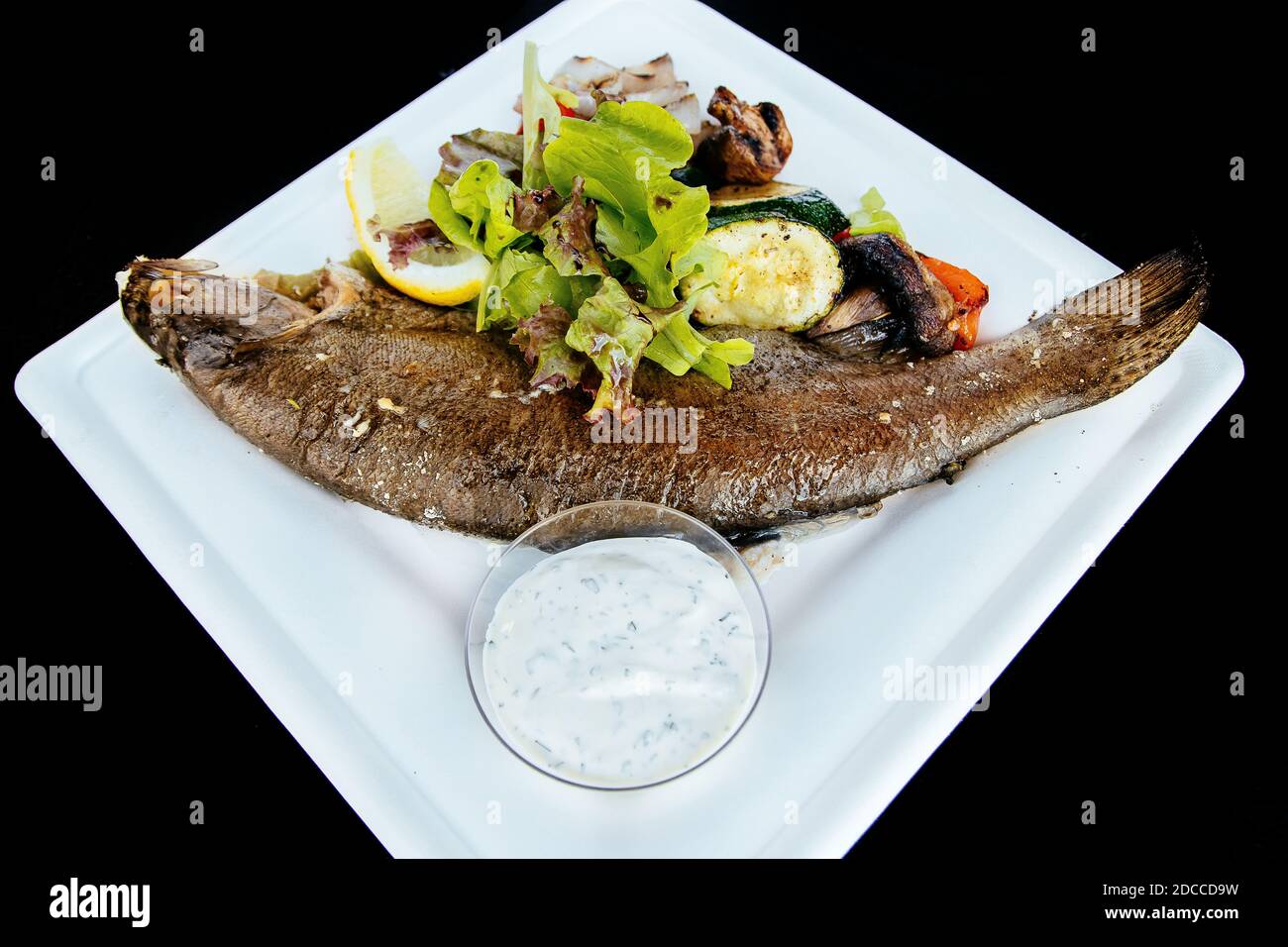 Whole fried trout with herbs and sauce Stock Photo Alamy