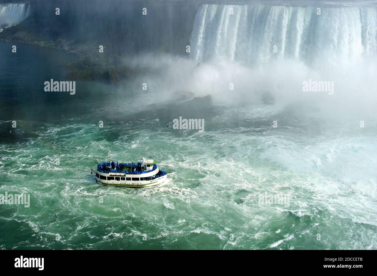 The Niagra Falls waterfalls viewed from the Canadian side with the Maid of the Mist tourist boat in the foreground Stock Photo