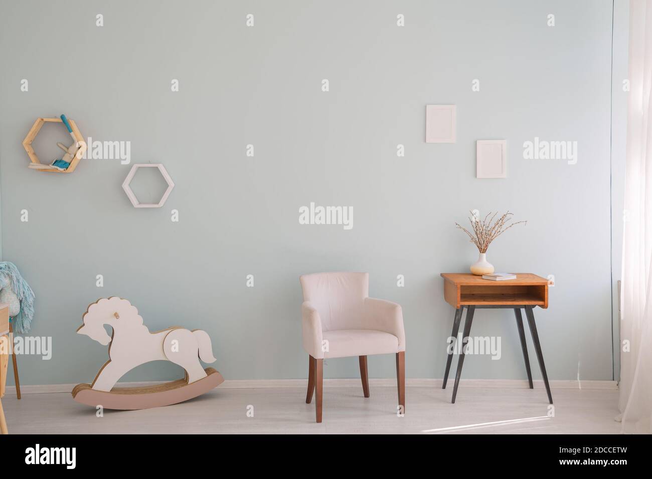Minimalistic nursery room with side cabinet, toys and wooden horse Stock Photo