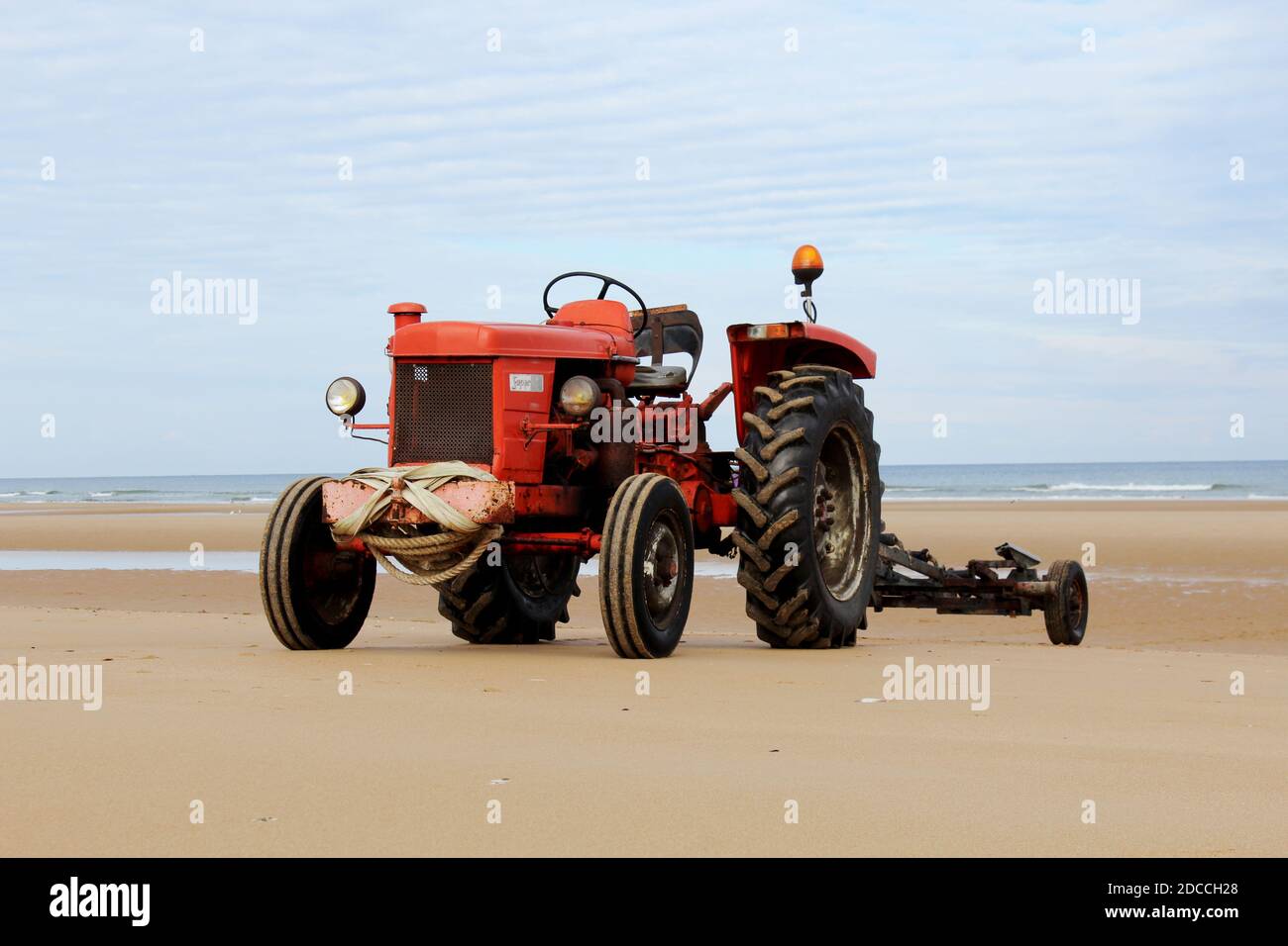 Ein roter Traktor am Strand von Omaha Beach, Normandie, Frankreich Stock Photo