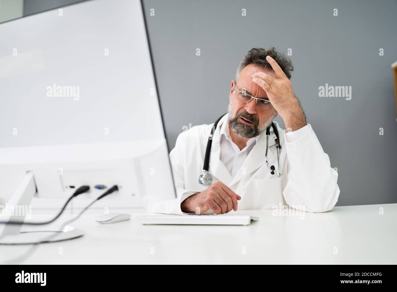Old Sad Man Doctor Stress And Pain At Computer Stock Photo