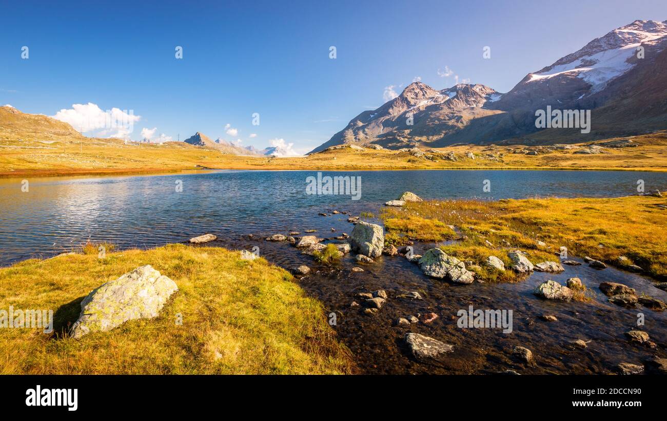 Sun is setting at Lej Pitschen, together with Lej Nair and Lago Bianco one of three lakes at The Bernina Pass. Stock Photo