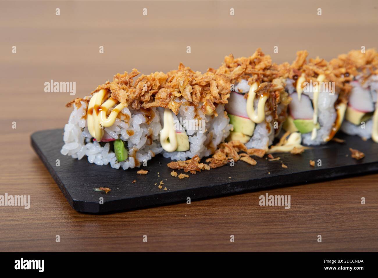 Crispy Sushi Roll with fried onion, avocado and crab. Sushi menu
