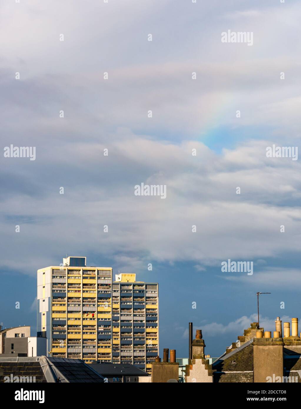 Council tower block of flats towering over rooftops with rainbow in sky, Leith, Edinburgh, Scotland, UK Stock Photo
