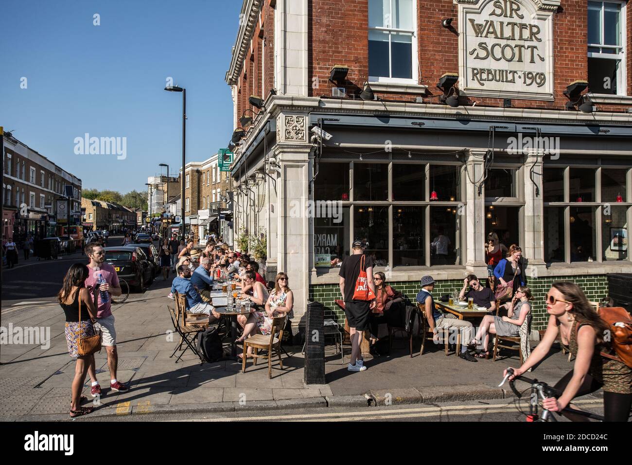 Cafe, restaurant on Broadway Street in East London. People have lunch at tables on the street Stock Photo