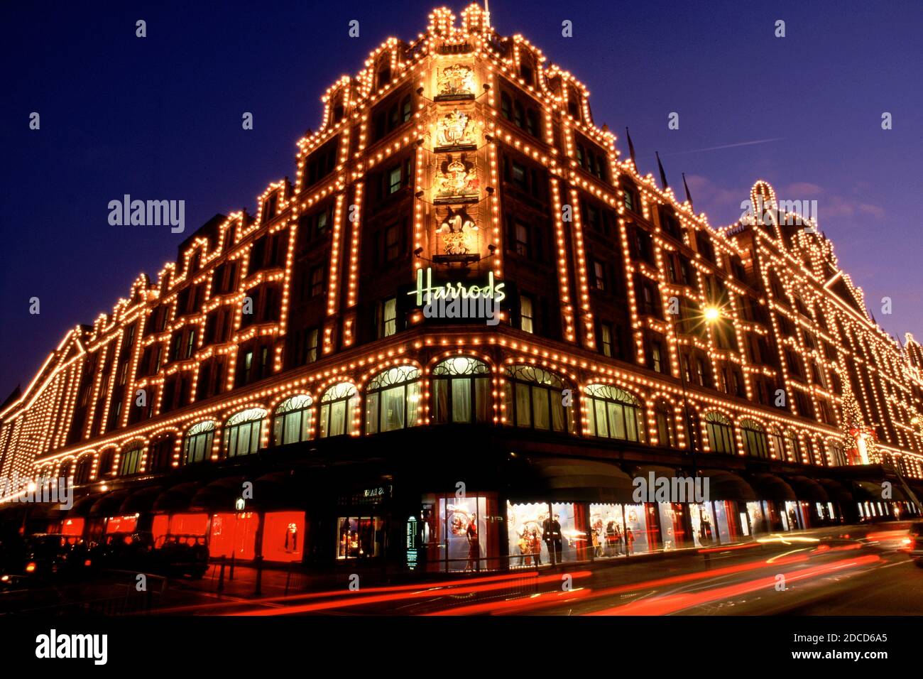 London, United Kingdom, Long exposure shot of Harrods department store in London during night with street traffic Stock Photo