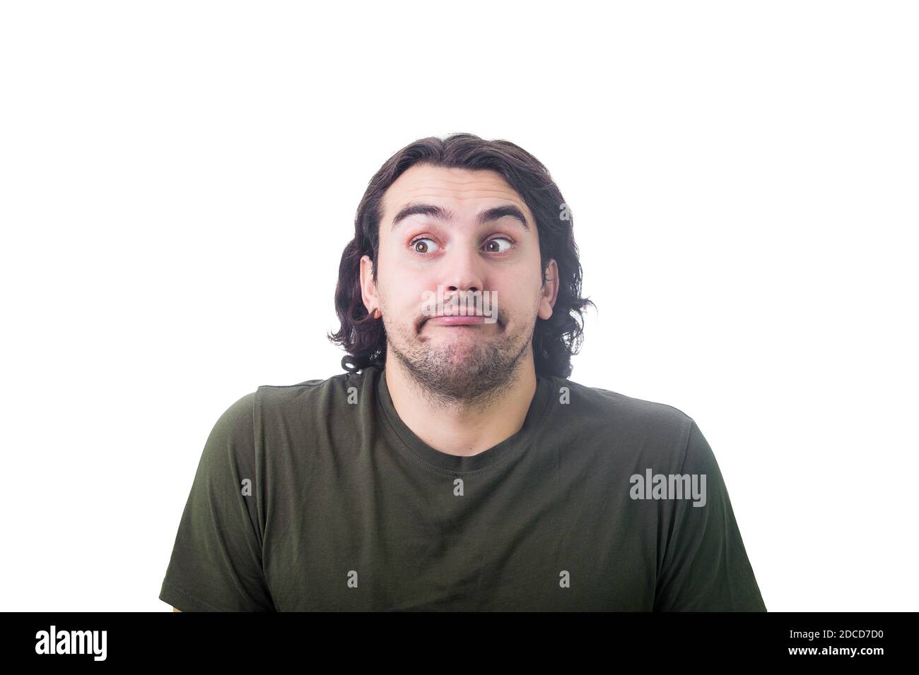 Portrait of naughty young man depicts innocent, funny face expression, looking aside, rolling eyes and hiding his glance isolated on white background. Stock Photo