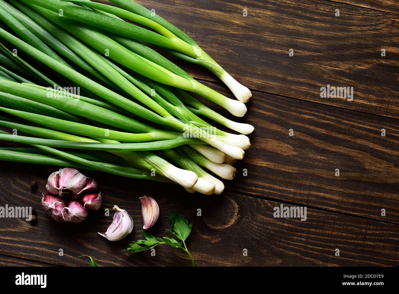 Fresh green onion and garlic on wooden background with free text space. Top view, flat lay Stock Photo