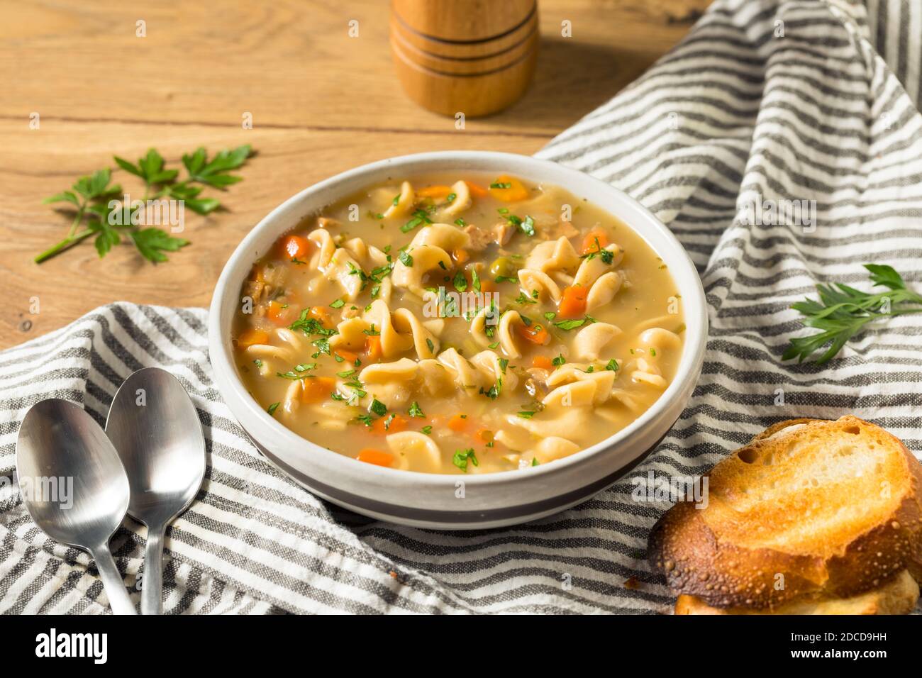 Homemade Chicken Noodle Soup with Peas and Carrots Stock Photo