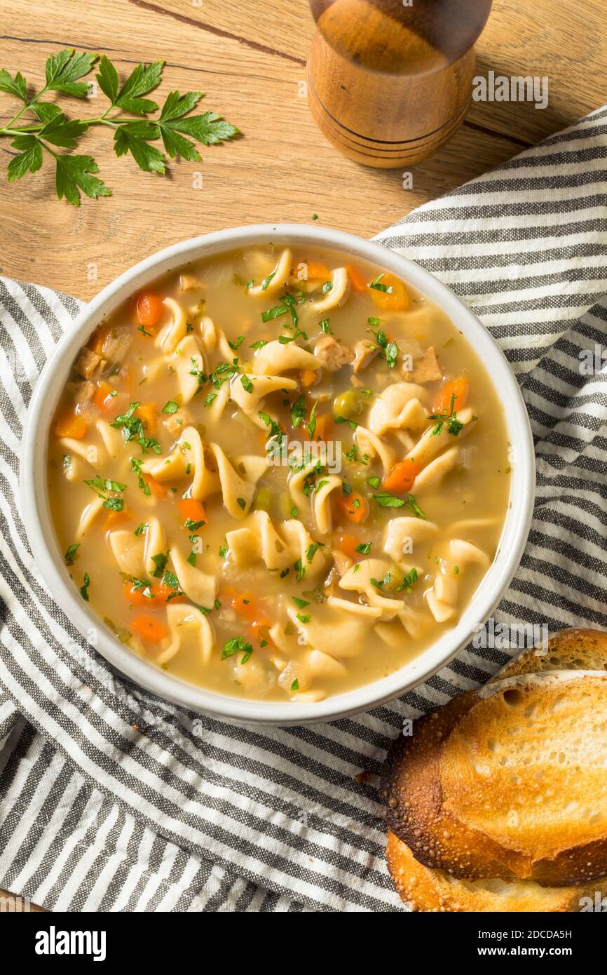 Homemade Chicken Noodle Soup with Peas and Carrots Stock Photo
